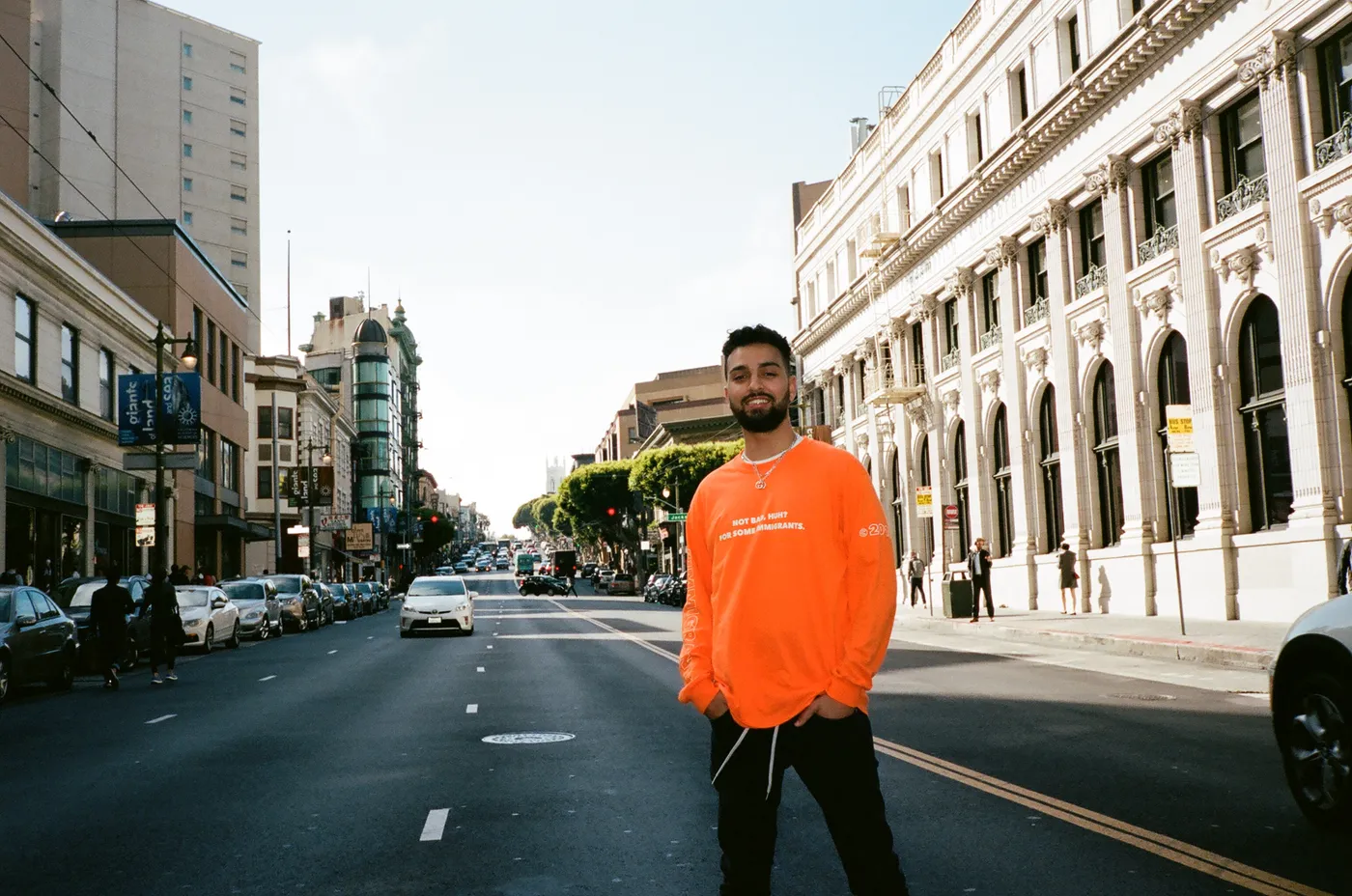 Model in the orange Not Bad, Huh? shirt standing in the middle of a city street